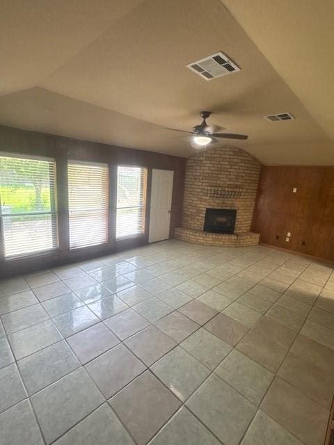 20114 Foxchester Ln, Humble, TX 77338 - unfurnished living room with ceiling fan, light tile patterned floors, wood walls, a fireplace, and lofted ceiling