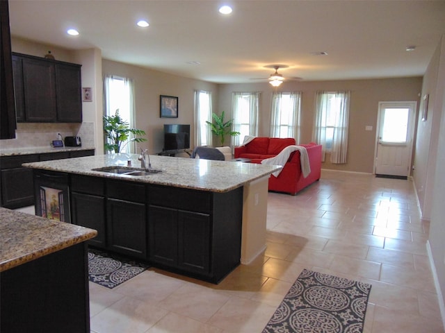 23727 Scotsman Dr, Katy, TX 77493 - kitchen with recessed lighting, an island with sink, light stone countertops, open floor plan, and tasteful backsplash