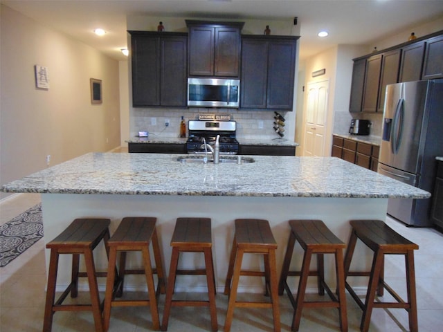 23727 Scotsman Dr, Katy, TX 77493 - kitchen featuring stainless steel appliances, decorative backsplash, a kitchen bar, recessed lighting, and a center island with sink
