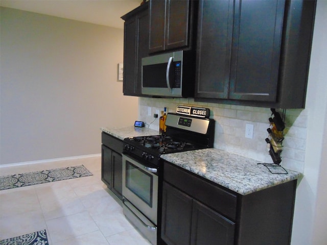 23727 Scotsman Dr, Katy, TX 77493 - kitchen featuring appliances with stainless steel finishes, decorative backsplash, light stone counters, and light tile patterned floors