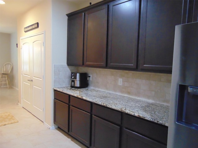 23727 Scotsman Dr, Katy, TX 77493 - kitchen with fridge with ice dispenser, decorative backsplash, light stone countertops, and dark brown cabinetry
