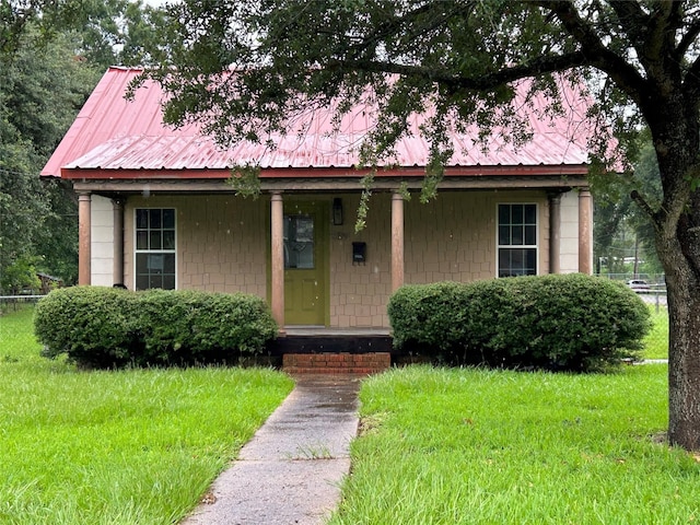 5119 33rd St, Groves, TX 77619 - bungalow with covered porch, a metal roof, and a front yard