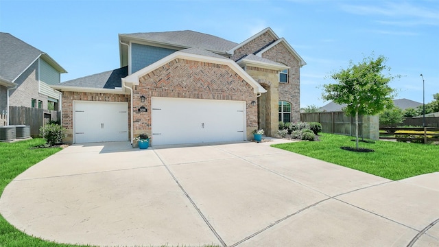 31319 Mallet Cv, Fulshear, TX 77441 - view of front of house with an attached garage, driveway, brick siding, and a shingled roof
