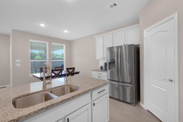 31319 Mallet Cv, Fulshear, TX 77441 - kitchen featuring stainless steel fridge, light stone counters, white cabinets, recessed lighting, and light wood-type flooring
