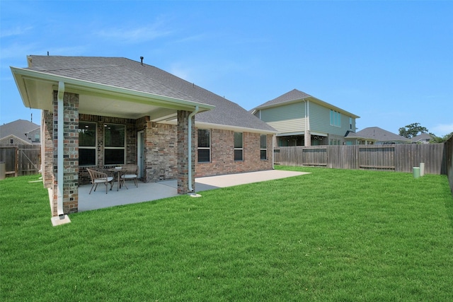 31319 Mallet Cv, Fulshear, TX 77441 - back of property with a shingled roof, a patio, brick siding, and a fenced backyard