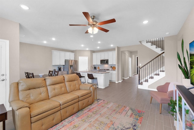 31319 Mallet Cv, Fulshear, TX 77441 - living room featuring ceiling fan, stairs, recessed lighting, and light wood-style flooring