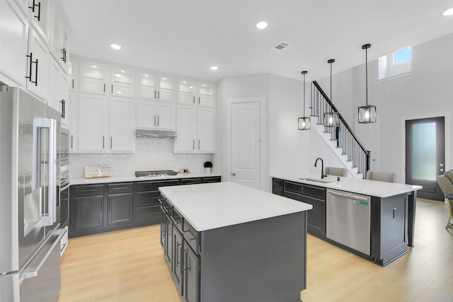16634 Lake Austin St, Cypress, TX 77433 - kitchen with stainless steel appliances, white cabinets, a peninsula, light wood finished floors, and recessed lighting
