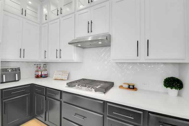16634 Lake Austin St, Cypress, TX 77433 - kitchen with under cabinet range hood, stainless steel gas cooktop, light countertops, and tasteful backsplash