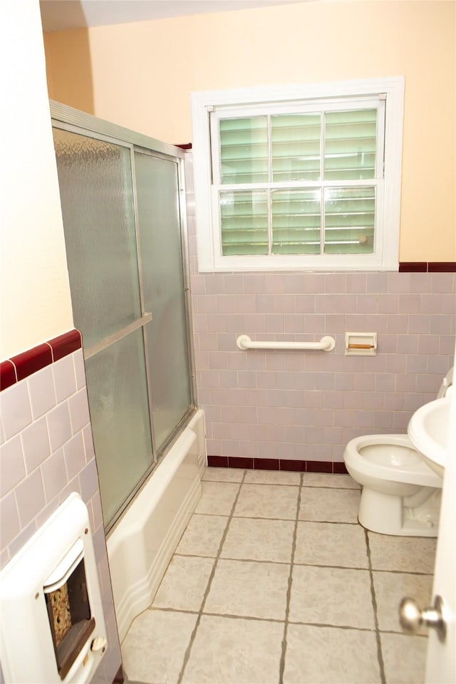 6718 E Bayou Dr, Hitchcock, TX 77563 - bathroom with tile walls, tile patterned floors, enclosed tub / shower combo, and wainscoting