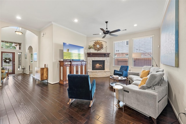 19718 Yellow Hibiscus Ln, Cypress, TX 77433 - living room featuring ceiling fan, arched walkways, a stone fireplace, crown molding, and healthy amount of natural light