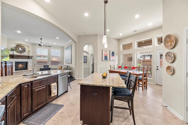 19718 Yellow Hibiscus Ln, Cypress, TX 77433 - kitchen with stainless steel dishwasher, a ceiling fan, a breakfast bar area, arched walkways, and recessed lighting