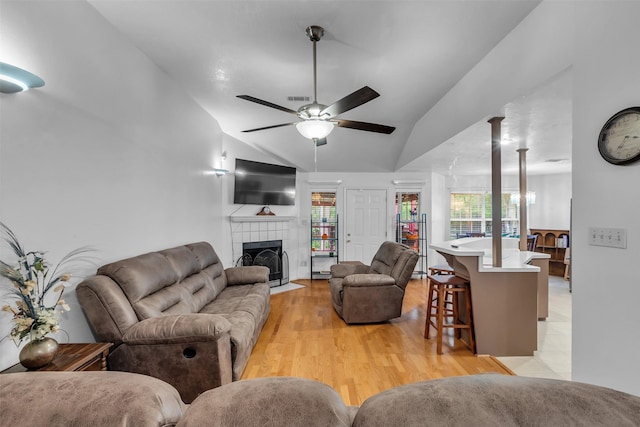 3360 Knob Oaks Dr, Huntsville, TX 77340 - living room with lofted ceiling, a ceiling fan, light wood-style floors, and a tiled fireplace
