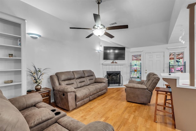 3360 Knob Oaks Dr, Huntsville, TX 77340 - living area featuring a ceiling fan, light wood-type flooring, lofted ceiling, built in features, and a tile fireplace