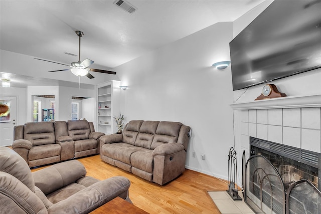 3360 Knob Oaks Dr, Huntsville, TX 77340 - living area with a ceiling fan, light wood finished floors, and a tiled fireplace