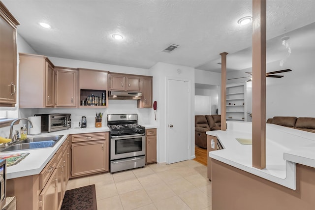 3360 Knob Oaks Dr, Huntsville, TX 77340 - kitchen featuring stainless steel range with gas stovetop, under cabinet range hood, open floor plan, light countertops, and open shelves