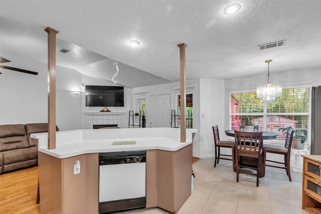 3360 Knob Oaks Dr, Huntsville, TX 77340 - kitchen with open floor plan, white dishwasher, light countertops, a textured ceiling, and a fireplace