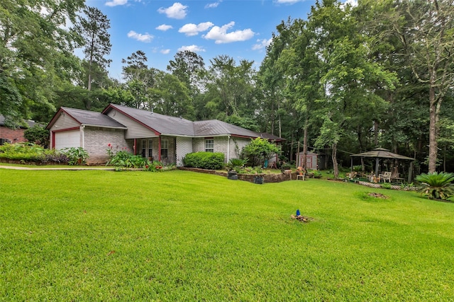 3360 Knob Oaks Dr, Huntsville, TX 77340 - view of front of home featuring a gazebo, a storage unit, a garage, a front lawn, and brick siding