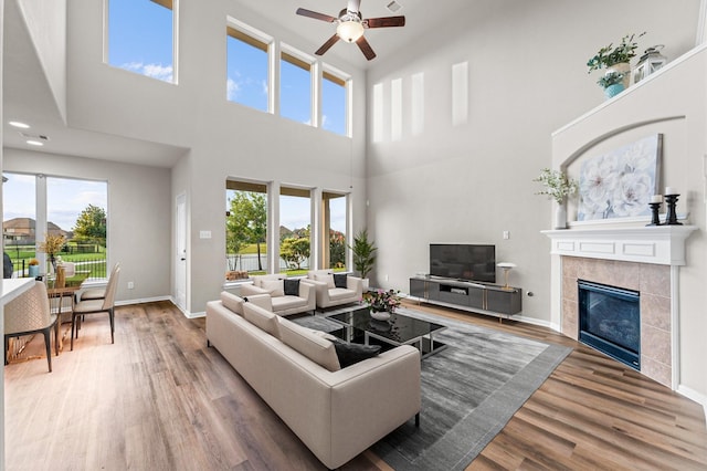 9415 Vista Falls Ct, Richmond, TX 77469 - living area featuring a towering ceiling, ceiling fan, wood finished floors, and a tiled fireplace