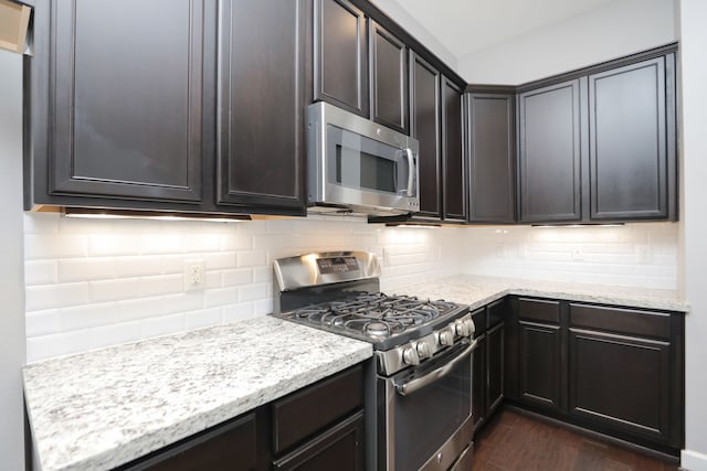 5120 Larkin St, Houston, TX 77007 - kitchen featuring stainless steel appliances, dark wood-type flooring, tasteful backsplash, and light stone counters