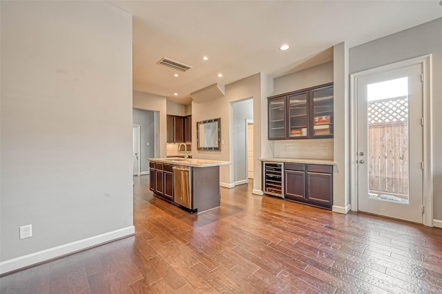 5120 Larkin St, Houston, TX 77007 - kitchen with wine cooler, stainless steel dishwasher, dark wood-style floors, a center island with sink, and glass insert cabinets