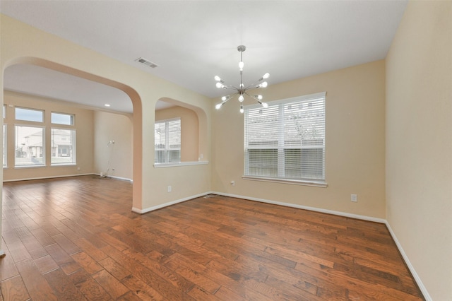 24030 Tirso River Ct, Katy, TX 77493 - unfurnished room with arched walkways, a chandelier, dark wood-style floors, and healthy amount of natural light