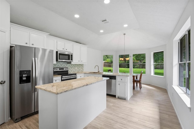 2403 Mustang Dr, Conroe, TX 77384 - kitchen with stainless steel appliances, a peninsula, white cabinetry, a center island, and recessed lighting