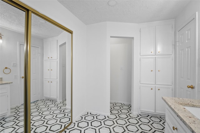 2403 Mustang Dr, Conroe, TX 77384 - full bathroom featuring a textured ceiling, vanity, and a closet