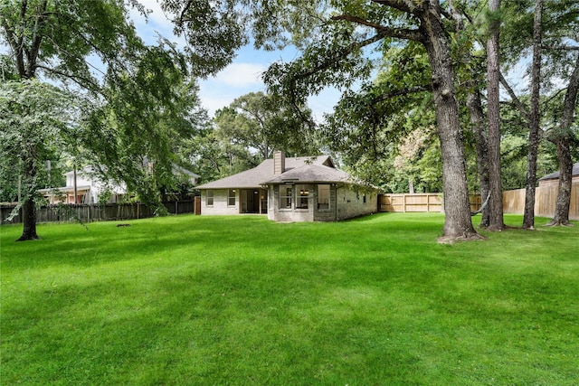 2403 Mustang Dr, Conroe, TX 77384 - back of property with a fenced backyard and a chimney
