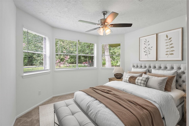 2403 Mustang Dr, Conroe, TX 77384 - bedroom with carpet flooring, multiple windows, ceiling fan, and a textured ceiling