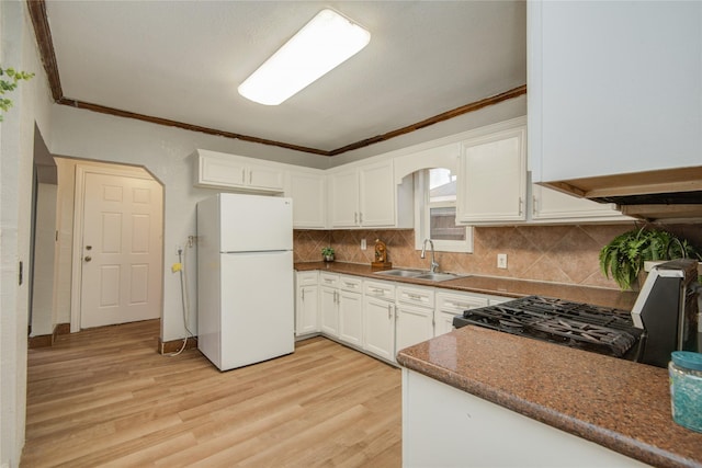 911 Wooding St, Houston, TX 77011 - kitchen featuring freestanding refrigerator, stove, ornamental molding, light wood-style flooring, and tasteful backsplash