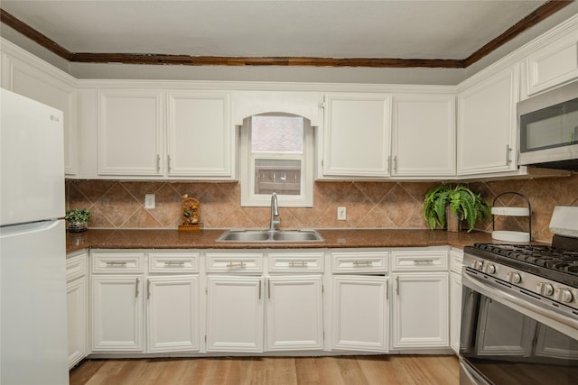 911 Wooding St, Houston, TX 77011 - kitchen with stainless steel appliances, white cabinets, crown molding, and decorative backsplash