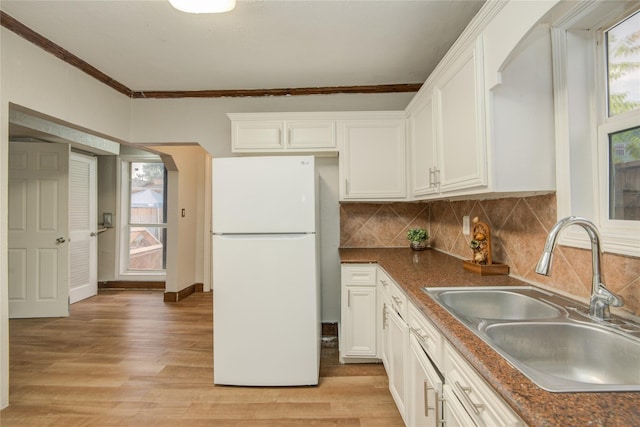 911 Wooding St, Houston, TX 77011 - kitchen featuring freestanding refrigerator, white cabinetry, light wood-style floors, dark countertops, and crown molding