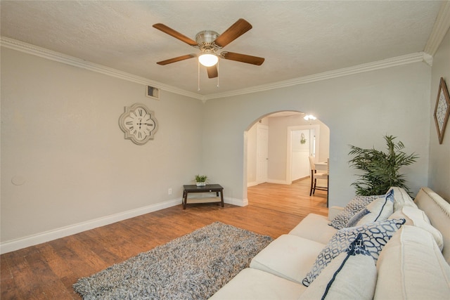 911 Wooding St, Houston, TX 77011 - living area featuring arched walkways, wood finished floors, a ceiling fan, and ornamental molding