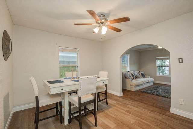911 Wooding St, Houston, TX 77011 - dining room featuring arched walkways, ceiling fan, and light wood finished floors