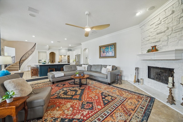 14002 Winding Springs Dr, Cypress, TX 77429 - living area featuring arched walkways, ceiling fan, stairs, ornamental molding, and a stone fireplace