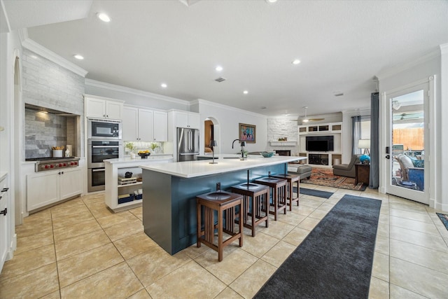 14002 Winding Springs Dr, Cypress, TX 77429 - kitchen featuring appliances with stainless steel finishes, a large island, crown molding, open floor plan, and light tile patterned floors