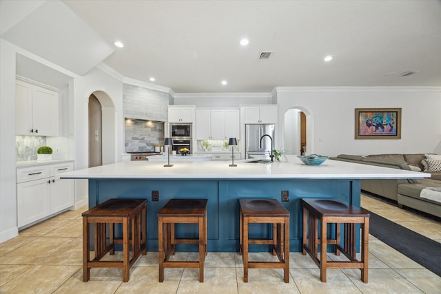 14002 Winding Springs Dr, Cypress, TX 77429 - kitchen featuring black microwave, arched walkways, backsplash, ornamental molding, and a kitchen breakfast bar