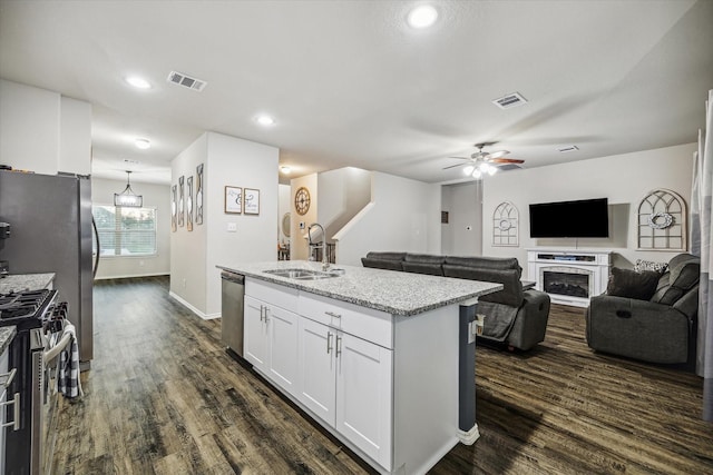 18827 Palmetto Hills Dr, New Caney, TX 77357 - kitchen featuring stainless steel appliances, dark wood finished floors, a ceiling fan, white cabinets, and an island with sink
