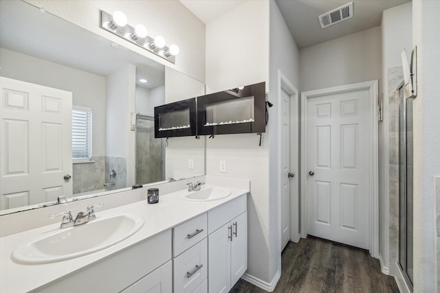 18827 Palmetto Hills Dr, New Caney, TX 77357 - bathroom with a tile shower, double vanity, and wood finished floors
