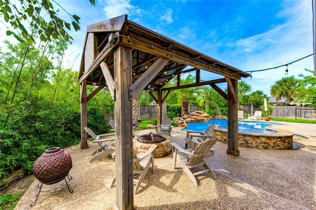 27818 Pinpoint Crossing Dr, Katy, TX 77494 - fenced backyard with an outdoor fire pit, a gazebo, a patio area, and an in-ground hot tub