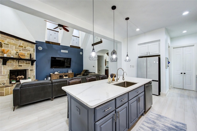 27818 Pinpoint Crossing Dr, Katy, TX 77494 - kitchen featuring open floor plan, a ceiling fan, arched walkways, light stone counters, and dishwasher