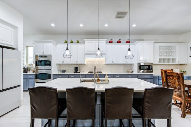 27818 Pinpoint Crossing Dr, Katy, TX 77494 - kitchen with appliances with stainless steel finishes, decorative backsplash, pendant lighting, white cabinetry, and recessed lighting