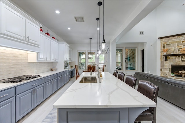 27818 Pinpoint Crossing Dr, Katy, TX 77494 - kitchen featuring stainless steel appliances, open floor plan, gray cabinetry, a large island with sink, and white cabinetry