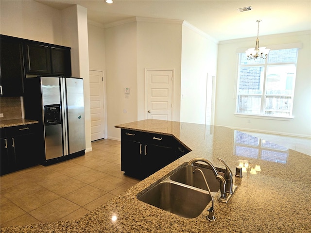 22106 Flashing Ridge Dr, Spring, TX 77389 - kitchen featuring stainless steel fridge, dark cabinetry, a chandelier, ornamental molding, and light tile patterned floors