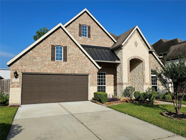 22106 Flashing Ridge Dr, Spring, TX 77389 - french country style house with a standing seam roof, driveway, and a garage