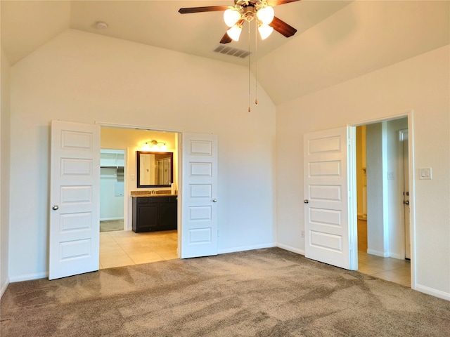 22106 Flashing Ridge Dr, Spring, TX 77389 - unfurnished bedroom with light carpet, high vaulted ceiling, light tile patterned floors, connected bathroom, and a walk in closet