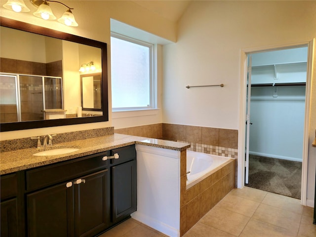 22106 Flashing Ridge Dr, Spring, TX 77389 - bathroom featuring a stall shower, a walk in closet, vanity, a garden tub, and tile patterned flooring