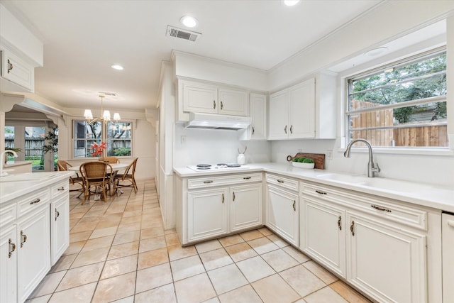 13307 Westport Ln, Houston, TX 77079 - kitchen featuring under cabinet range hood, a chandelier, recessed lighting, light countertops, and white cabinets