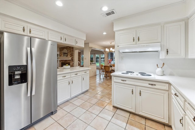13307 Westport Ln, Houston, TX 77079 - kitchen with stainless steel fridge, white electric stovetop, a chandelier, under cabinet range hood, and light countertops