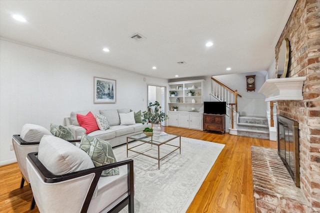 13307 Westport Ln, Houston, TX 77079 - living room with stairway, light wood-style flooring, recessed lighting, crown molding, and a brick fireplace